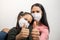 Mother and daughter raise their thumbs up as a sign that everything will be fine after the global coronavirus infection