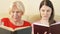 Mother and daughter reading physical print books. Concept of traditional classical paper reading