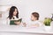 Mother and daughter reading time. Learning together sitting at the table.