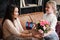Mother and daughter relationship concept. A teenage girl congratulates happy woman on her birthday and gives her flowers