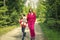 Mother and daughter on the relaxing spring walk through the green forest