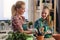 Mother and daughter repotting plants together at home garden