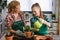 Mother and daughter repotting plants together at home garden