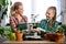 Mother and daughter repotting plants together at home garden