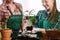 Mother and daughter repotting plants together at home garden