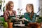 Mother and daughter repotting plants together at home garden