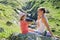 Mother and daughter resting on the big stone at travel excursion.