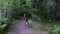 Mother and daughter ride bicycle in the forest