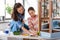 mother and daughter with ruler measuring old table