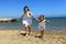 Mother and daughter running on beach