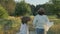 Mother and daughter running holding hands, back view