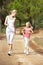 Mother and daughter running in park