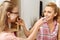 Mother and daughter sharing delicious cake with one another