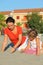 Mother with daughter sit on beach and draw on sand