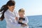 Mother and daughter sitting on the beach holding the Bible