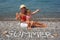 Mother and daughter sitting on beach near water