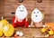 Mother and daughter sitting behind a table in halloween decorated room, playing with ghost character balloons.