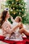 Mother and daughter sitting at Christmas tree