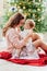 Mother and daughter sitting at Christmas tree