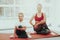 Mother And Daughter Sitting On Gym Carpet At Home.