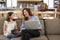 Mother And Daughter Sitting On Lounge Sofa Using Digital Devices