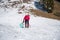 Mother and daughter sledging across fresh snow covered slopes.