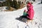 Mother and daughter sledging across fresh snow covered slopes.