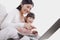 Mother and daughter smiling and sitting close together on the sofa, using and pointing at the laptop, tilt