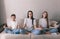 Mother daughter and son are sitting on the sofa in the lotus position engaged in meditation