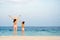 Mother and daughter spread their hands on beautiful beach