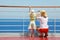 Mother and daughter standing on deck of yacht