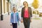 Mother and daughter student walking to school.