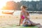 Mother and daughter sunbathing on the tropical beach. They are Looking in the direction of the sunset and enjoy it