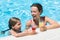 Mother and daughter swimming with drink in hand