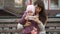 Mother and daughter take sefi while sitting on a bench near a busy road.