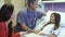 Mother And Daughter Talking With Male Nurse in Hospital Room