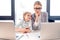 Mother and daughter talking while sitting at table with laptops