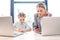 Mother and daughter talking while sitting at table with laptops