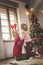 Mother and daughter tickling by the Christmas tree