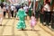 Mother and daughter in traditional dress walking alongside Casetas at the Seville Fair