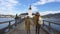 Mother and daughter travelers are walking by the wooden bridge to the famous beautiful castle Schloss Ort, lake Traunsee, Austria