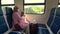 Mother and daughter traveling in the train - women setting on the bench and looking to window