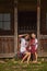 mother and daughter in Ukrainian folk dresses are sitting near the house