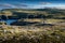 Mother and daughter walk across mossy tundra along the Klondike trail near the famous Chimney Rock in Newfoundland Canada