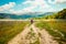 Mother and daughter walk on road through field