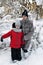 Mother and daughter walk in the snowy forest.