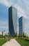 Mother and daughter walking the dog in the CityLife park during a sunny day. Hadid and the Isozaki towers in the