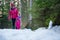 Mother and daughter walking a snowy forest.