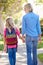 Mother And Daughter Walking To School On Suburban Street