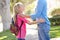 Mother And Daughter Walking To School On Suburban Street